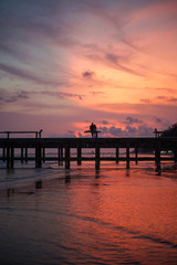 Fototapeta na wymiar ouple silhouette standing on jetty in sunset twilight