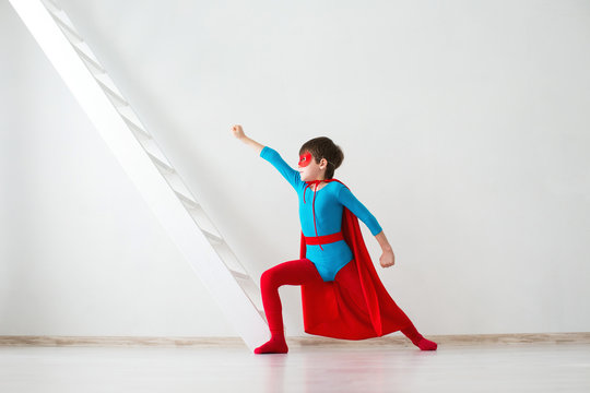 Boy dreamer in costume and pose superhero.