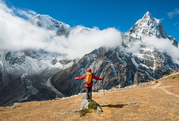 Fototapeta premium Trekker standing in front of Mt.Taboche (6,501 m) at the left side and Mt.Cholatse (6,440 m) at the right side during trekking from Lobuche to Dzongla village in Nepal.