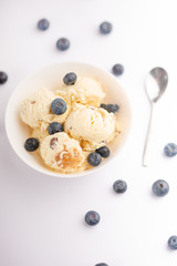 ice cream with blueberries, on a white background with a spoon. on a white background, summer mood