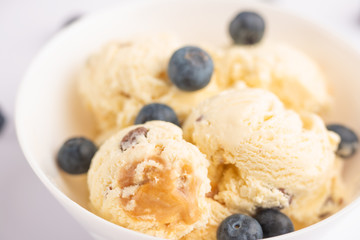 ice cream with blueberries, on a white background with a spoon. close-up, summer mood