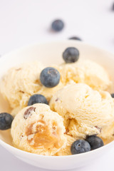 ice cream with blueberries, on a white background with a spoon. close-up, summer mood
