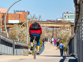 The 606 Bloomingdale Trail is busy with pedestrians and cyclists in Bucktown. Streets of Chicago.