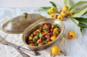 with a loquat dish. Meatballs with a loquat. or mini kebabs. medlar fruit with meatballs. Soft focus. Place for text. Copy Space