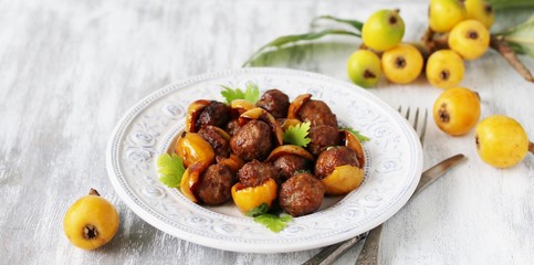 with a loquat dish. Meatballs with a loquat. or mini kebabs. medlar fruit with meatballs. Soft focus. Place for text. Copy Space