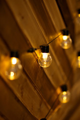 Hanging light bulbs on a wooden wall. Background wooden boards with lamps