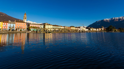 Fototapeta premium Ascona, Switzerland - December 2013: luxury tourist resort promenade on Lake Maggiore in Ticino canton in Switzerland in summer. People outdoor street travel. Romantic Swiss holiday