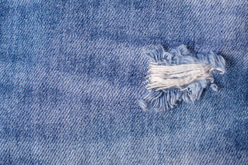 Destroyed Torn Blue jeans background. Close up blue textures ripped jeans