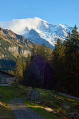 Fototapeta na wymiar Jungfrau mountain at sunset and the old barn near Swiss Alpine village Wengen in Switzerland.