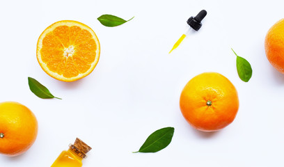 Essential oil with oranges on white.