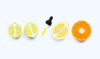Orange, lime and lemon with dropper on white