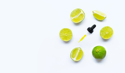 Essential oil with limes on white.