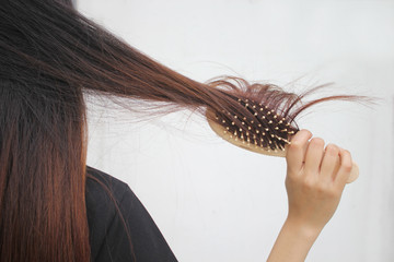 Woman holding combing with brush and clean long hair, Haircare concept