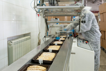 Pancakes are fried on the conveyor in factory