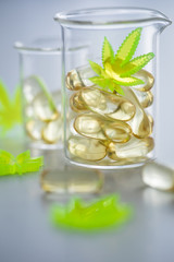Pillen, Tabletten, Kapseln mit Cannabis Marihuana Hanf und CBD in Labor Becherglas gegen Schmerzen zur Therapie als Medizin 