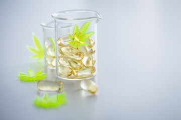 Pillen, Tabletten, Kapseln mit Cannabis Marihuana Hanf und CBD in Labor Becherglas gegen Schmerzen zur Therapie als Medizin 