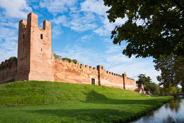 city wall with merlons and tower on green hill in Castelfranco Veneto, Italy