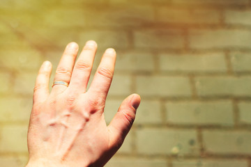 A man's hand with a wedding ring on his finger