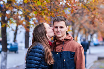 Lovers. A loving couple walks around the city. A loving couple holding hands. Couple hug and kiss. Romantic walk of lovers. Romantic walk by the spring street. Portrait photo of lovers.