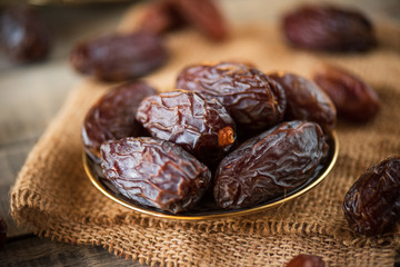 Ramadan food and drinks concept. Dates fruit in a bowl on wooden table background.