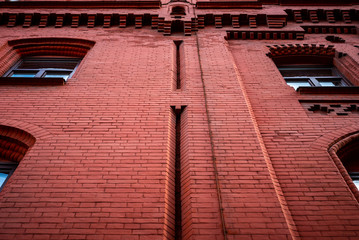 Red brick wall with windows. Bottom view.