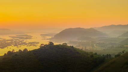 Fototapeta premium sunrise at Phu Huay E San View Point, view of the hill around with sea of mist above Mekong river with red sun light in the sky background, Ban Muang, Sang Khom District, Nong Khai, Thailand.