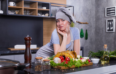 Pretty young blondie chef cooker preparing chicken or turkey in uniform with knife, spices, herbs, oil. Food, cooker concept
