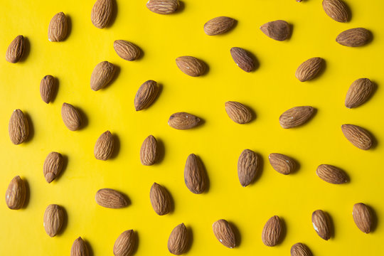 Fresh dry almond on yellow background. Top view