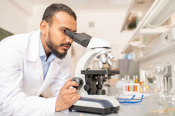 Researcher working with microscope