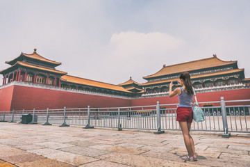 Fototapeta premium China travel lifestyle. Asian woman taking smartphone picture of Beijing tourist attraction, ancient dynasty building.