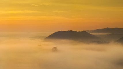 sunrise at Phu Huay Esan View Point, view of the hill around with sea of mist above Mekong river with yellow sun light in the sky background, Ban Muang, Sang Khom District, Nong Khai, Thailand.