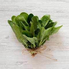 Fresh raw spinach on a white wooden background. Flat lay, overhead, from above. Close-up.