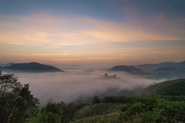 sunrise at Phu Huay Esan View Point, view of the hill around with sea of mist above Mekong river with soft red light in the sky background, Ban Muang, Sang Khom District, Nong Khai, Thailand.