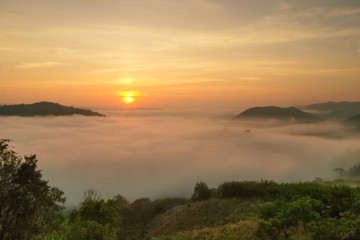 sunrise at Phu Huay Isan View Point, view of the hill around with sea of mist above Mekong river with yellow sky background, Ban Muang, Sang Khom District, Nong Khai, Thailand.