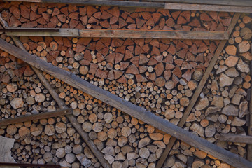 Sawn trees. Wooden logs stacked. The wooden felled trees are stacked on top of each other. Background image of sawn trees. Wood texture.