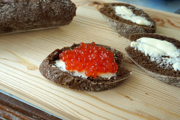baguette with caviar and butter on a wooden board