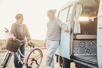 Happy people senior age couple smile and enjoy outdoor travel leisure activity together with vintage bike and van for alternative summer vacation concept - retired lifestyle
