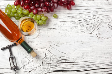 Naklejka na ściany i meble White wine bottle, grape, honey, cheese and wineglass on white wooden board