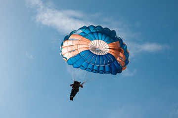 Round parachute against the sky with clouds in an unusual color scheme. Two-color process.