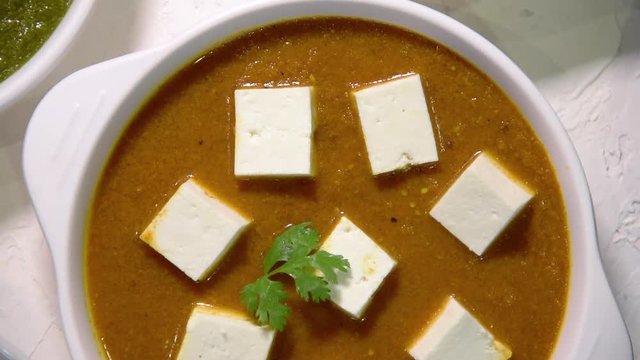 Indian vegetarian  platter / Thali having Palak paneer butter masala, dal makhani, flat bread or naan and rice served in a white plate