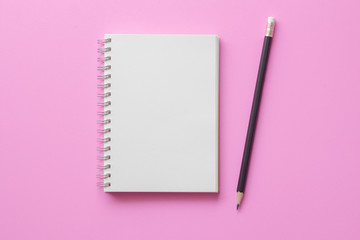 Blank note book with pencil on pink background.minimal style.