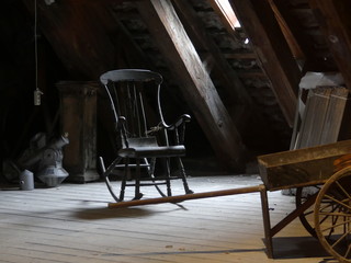 Old rocking chair in the attic. Old chair in the attic. Cart in the attic. Strict, unnecessary...
