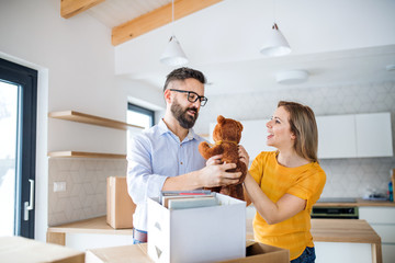 A young couple moving in new home, having fun.