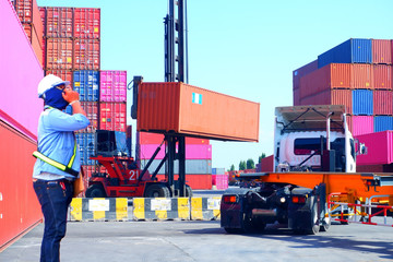 Foreman control loading containers box from cargo freight ship for import export, Foreman control industrial container cargo freight ship, Business logistic concept, Import and export concept