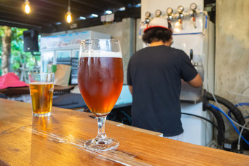 Cold glasses of craft beer on wooden table.