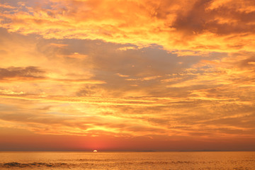 Sunset over the sea with islands at horizon