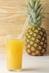 Ripe pineapple fruit and pineapple juice close-up on a natural wooden background. summer.