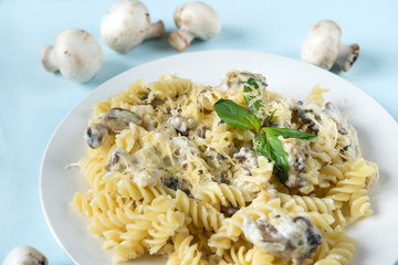 plate of pasta with mushrooms and cheese, sprig of Basil, fresh mushrooms