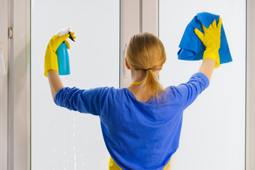 Woman cleaning window at home