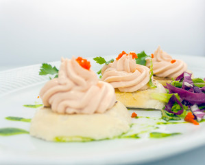 tartlets with red caviar, butter, sprigs of parsley and lettuce on a white plate on a white background